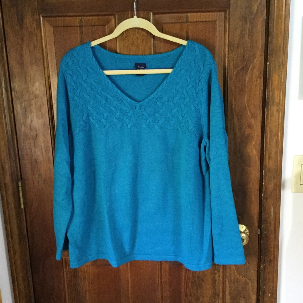 Turquoise sweater with textured pattern.